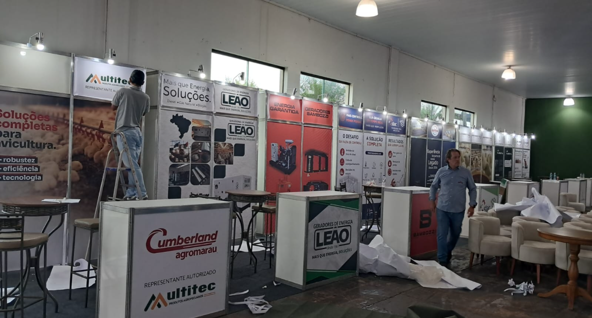 Fileira de stands montados em pavilhão de feira